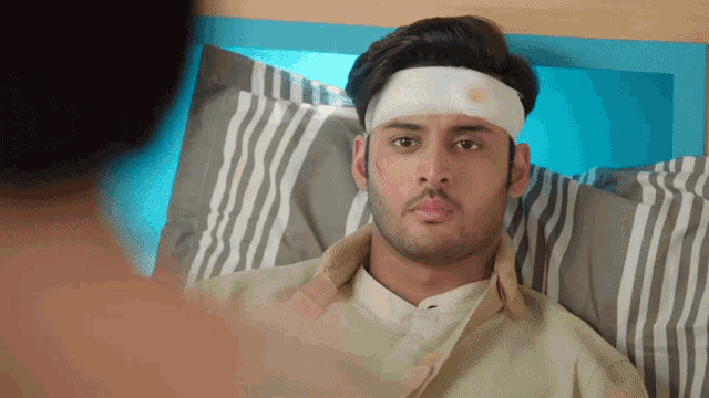 a man with a bandage on his head laying in bed