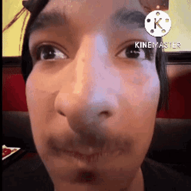 a close up of a man 's face with a k on the corner