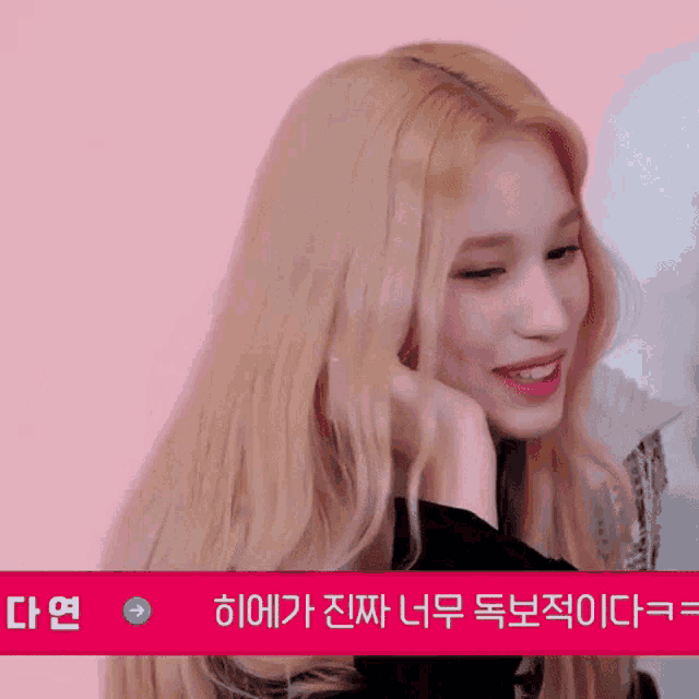 a woman with blonde hair is smiling with a pink background