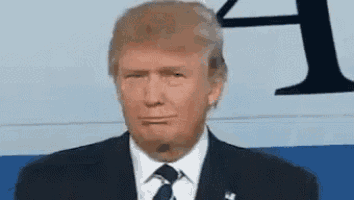 donald trump is wearing a suit and tie while making a funny face .