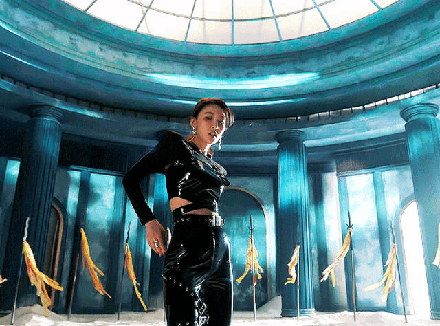a woman stands in a room with columns and a dome