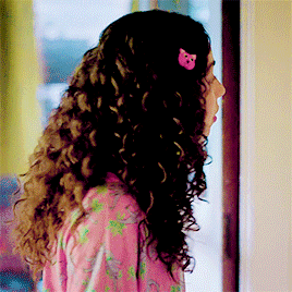 a girl with curly hair has a pink cat hair clip