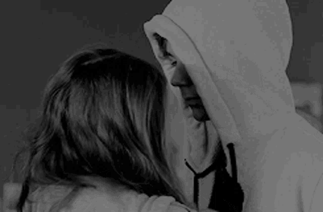 a black and white photo of a woman covering her face with her arms .