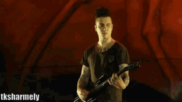 a blurred image of a man playing drums with the words tksharmely visible in the corner
