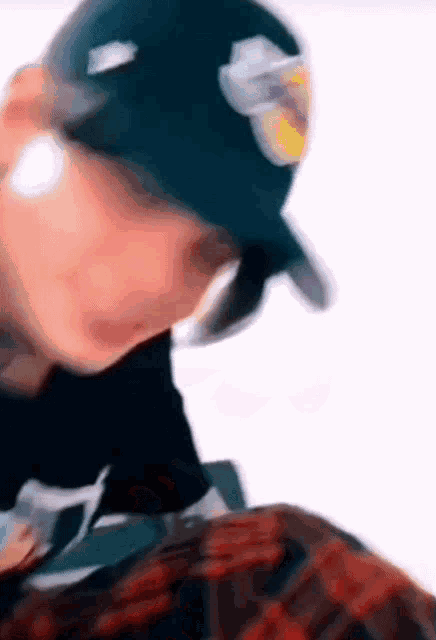 a blurry picture of a person wearing a hat and a plaid shirt .