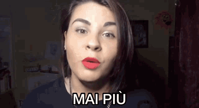 a woman with red lipstick is making a rude gesture and the words mai piu are above her