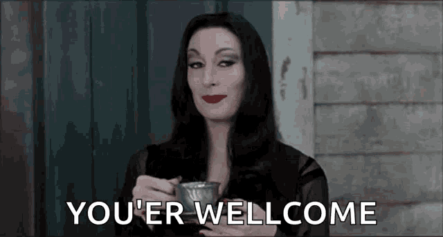 a woman is holding a cup of coffee and saying `` you 're well come '' .