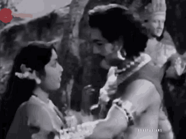 a man and a woman are standing next to each other in a black and white movie .