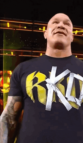 a bald man wearing a black t-shirt that says rkd