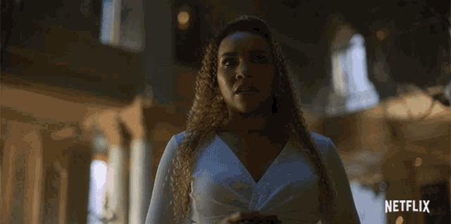 a woman in a white dress is standing in front of a netflix logo