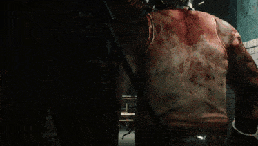 a man with a bandage on his head is standing next to a bloody man