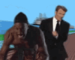 a blurry picture of a man in a suit and tie standing next to a naked man