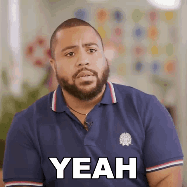 a man with a beard wearing a blue shirt says yeah