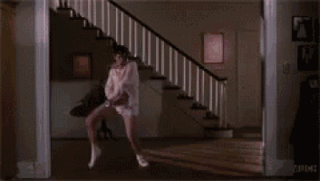 a man in underwear is dancing on a set of stairs in a house .