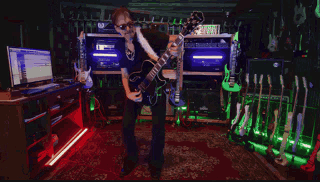 a man is playing a guitar with a feather boa around his neck