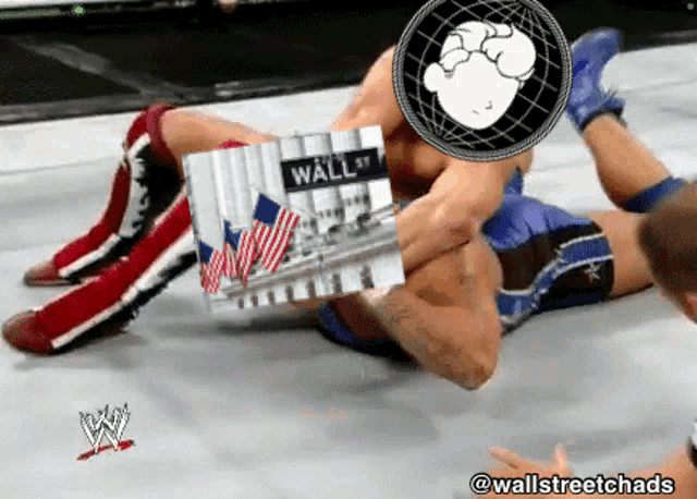 a wrestling match with a picture of wall street on the mat