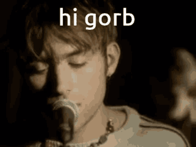 a close up of a man singing into a microphone with the words hi gorb above him