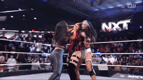 two women are wrestling in a ring with nxt written in the background