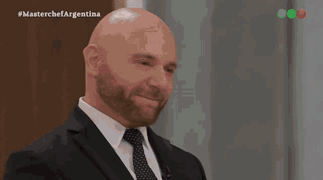 a bald man in a suit and tie is on a television show called masterchef argentina
