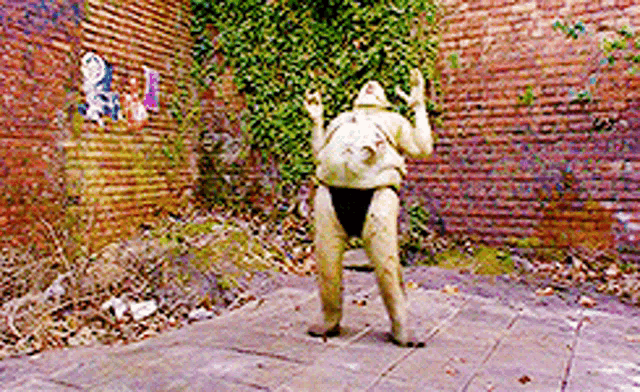 a statue in front of a brick wall that says ' a ' on it