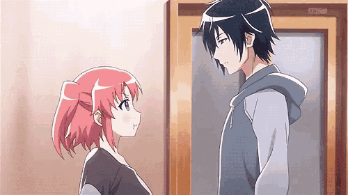 a man and a woman are standing next to each other in front of a door .