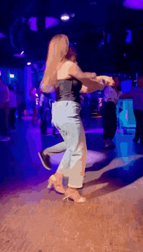 a man and a woman are dancing together in a dark room .