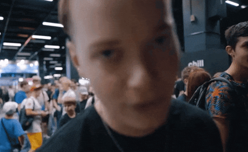 a blurry picture of a man in a crowd with the word chill on the wall behind him