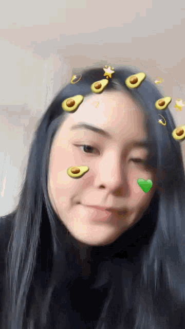 a girl with avocados on her face and a heart on her cheek