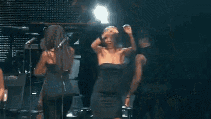 a group of people are dancing on a stage in front of a microphone .