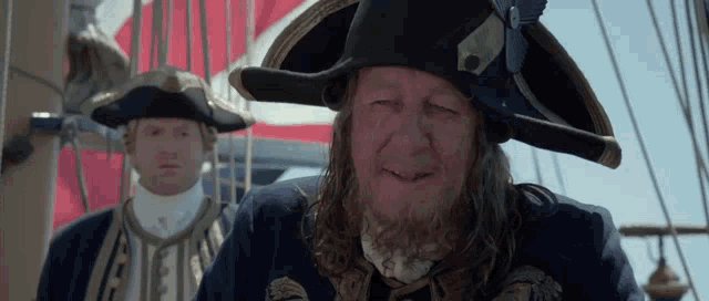 a man with long hair and a beard is wearing a hat