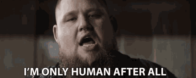 a man with a beard is singing and says i 'm only human after all