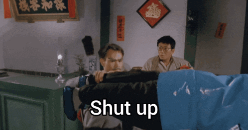 two men in a room with the word shut up written on the bottom