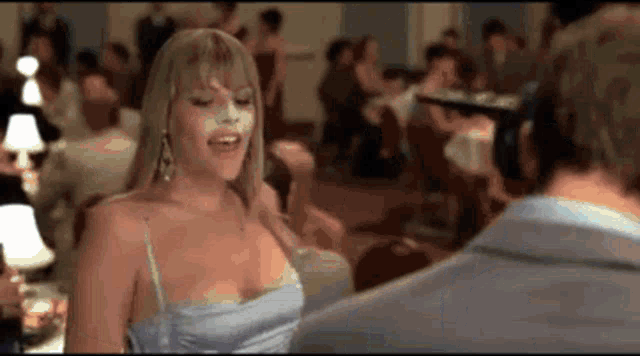 a woman in a blue dress is dancing with a man .