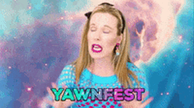 a woman in a blue shirt is standing in front of a yawnfest sign