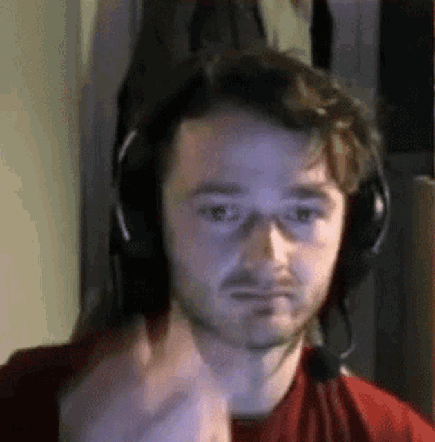 a man wearing headphones is giving a thumbs up .