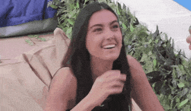 a woman is sitting on a bean bag chair laughing