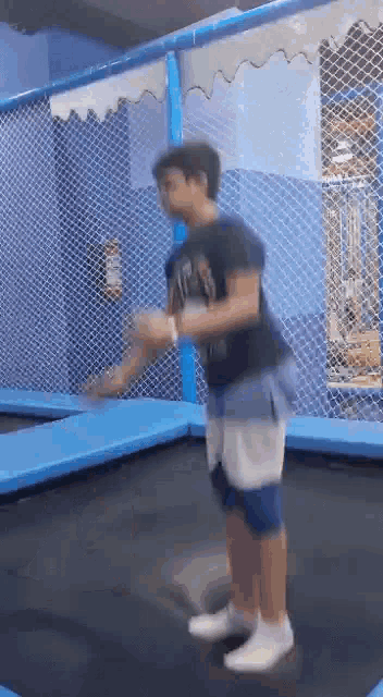 a young boy is jumping on a trampoline in a playground .