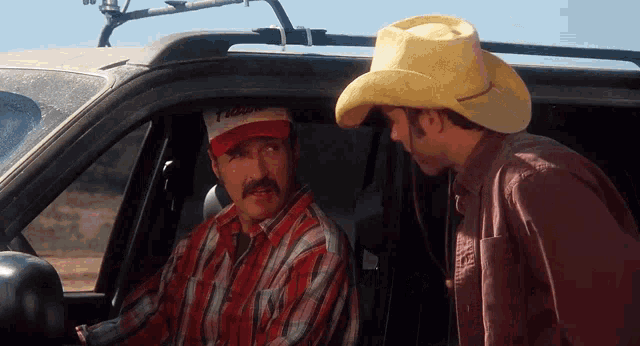 two men in cowboy hats are talking in a car and one of them is wearing a hat that says tigger