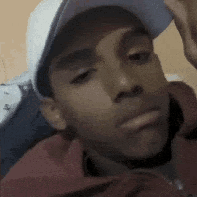 a young boy wearing a baseball cap and a red jacket looks at the camera .