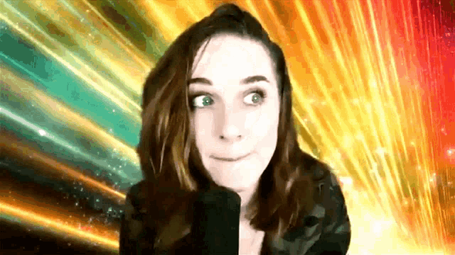 a woman is making a funny face in front of a brightly colored background
