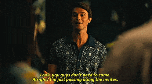 a man in a blue shirt is talking to another man and says `` look , you guys don t need to come . ''