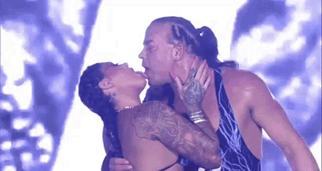 a man and a woman are kissing on a stage in front of a crowd .