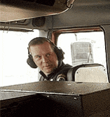 a man wearing headphones is sitting in the driver 's seat of a car