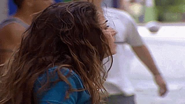 a woman with wet hair is standing in the rain .