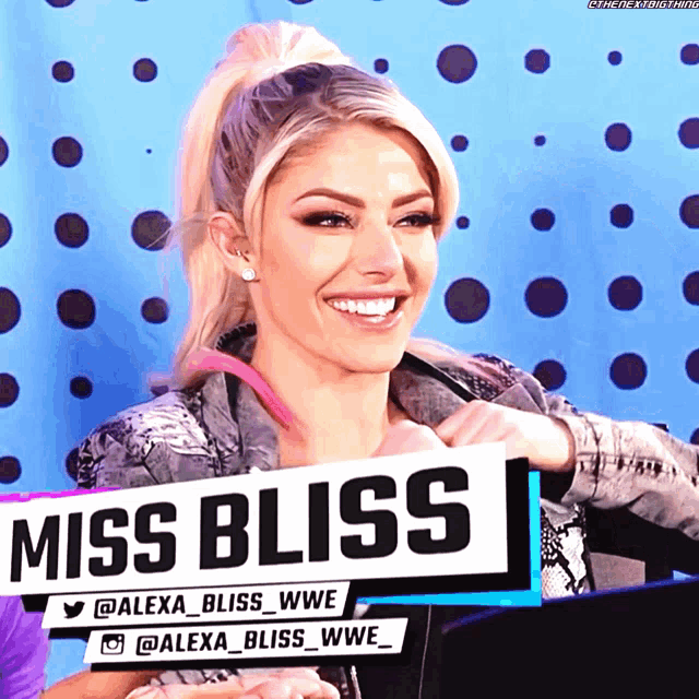 miss bliss is smiling and holding a sign
