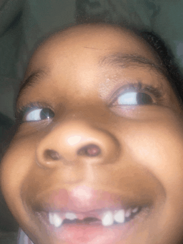 a close up of a child 's face with a smile