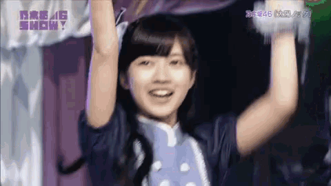 a girl in a blue dress is holding her arms in the air .