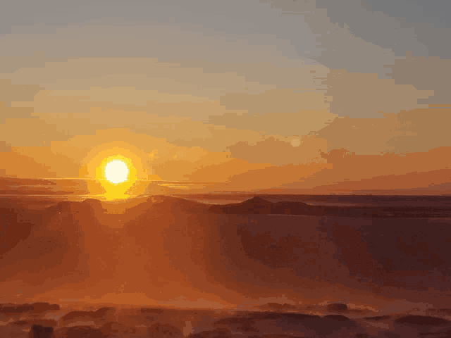 the sun shines brightly over the mountains at sunset