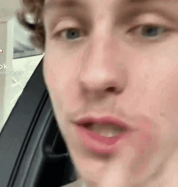 a close up of a young man 's face in a car .