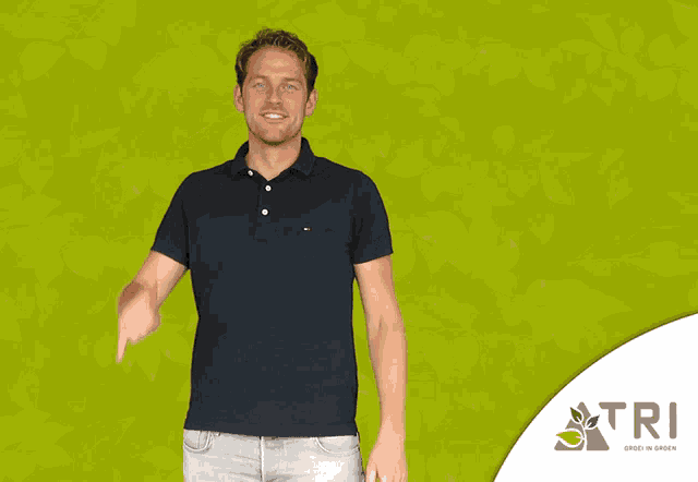 a man is pointing at himself in front of a green background with tri written on it